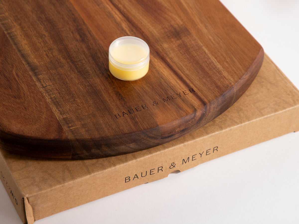 Detail van de rand van de Snijplank Acacia S500 met gegraveerd BAUER & MEYER-logo en potje waxolie
