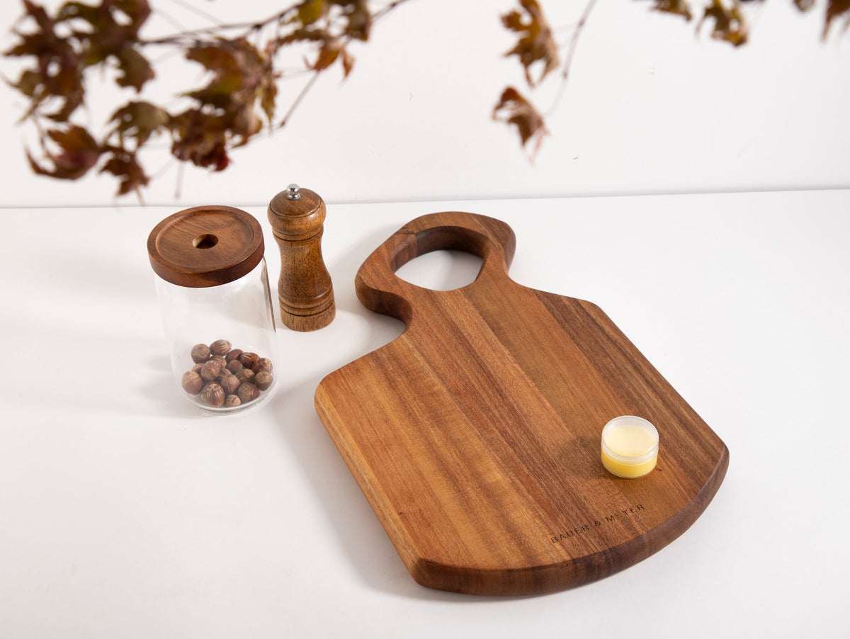 Snijplank Acacia S600 plat op tafel met potje waxolie, voorraadpot en pepermolen